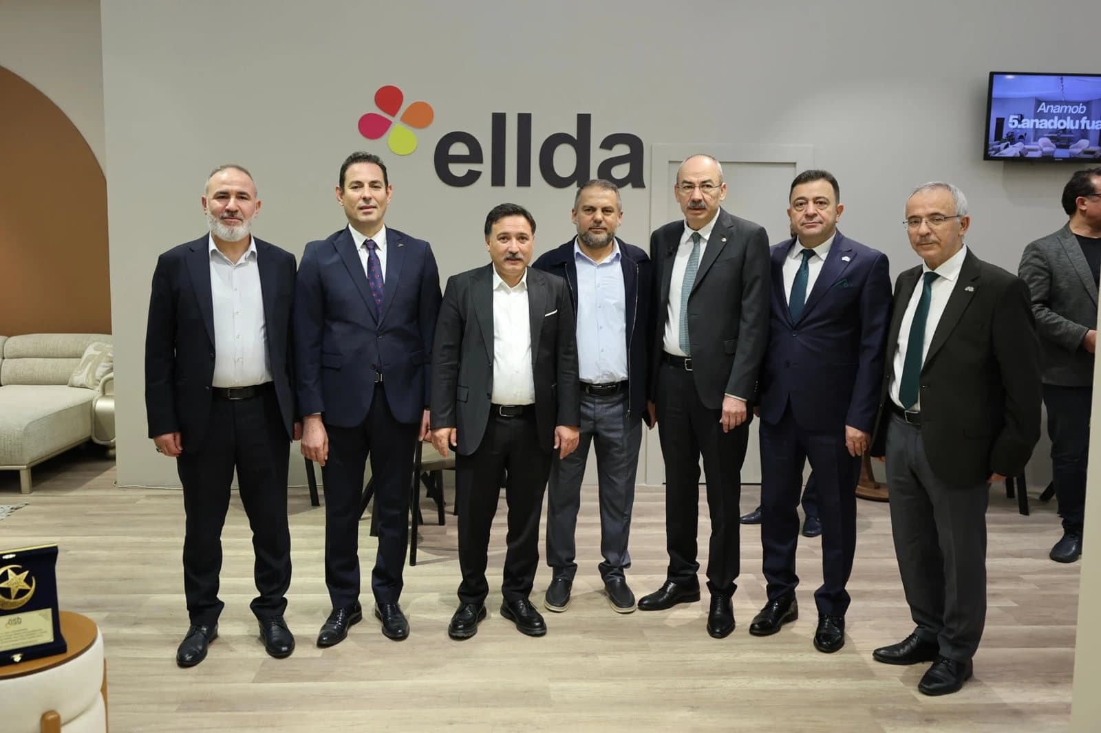 ANAMOB 2026'da ellda mobilya standı, logonun önünde açılış programındaki heyet